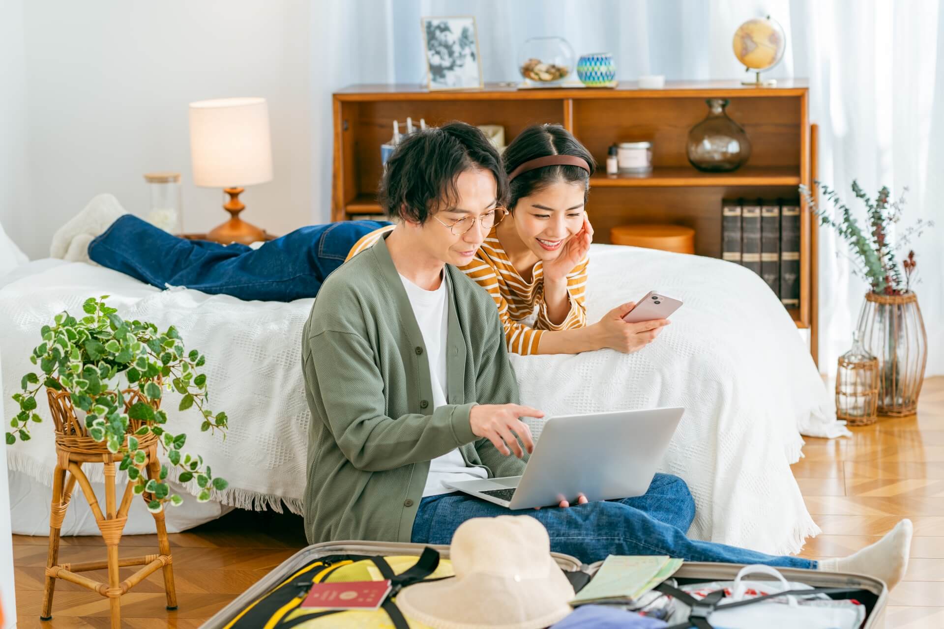 明るい部屋でノートパソコンを使う夫婦