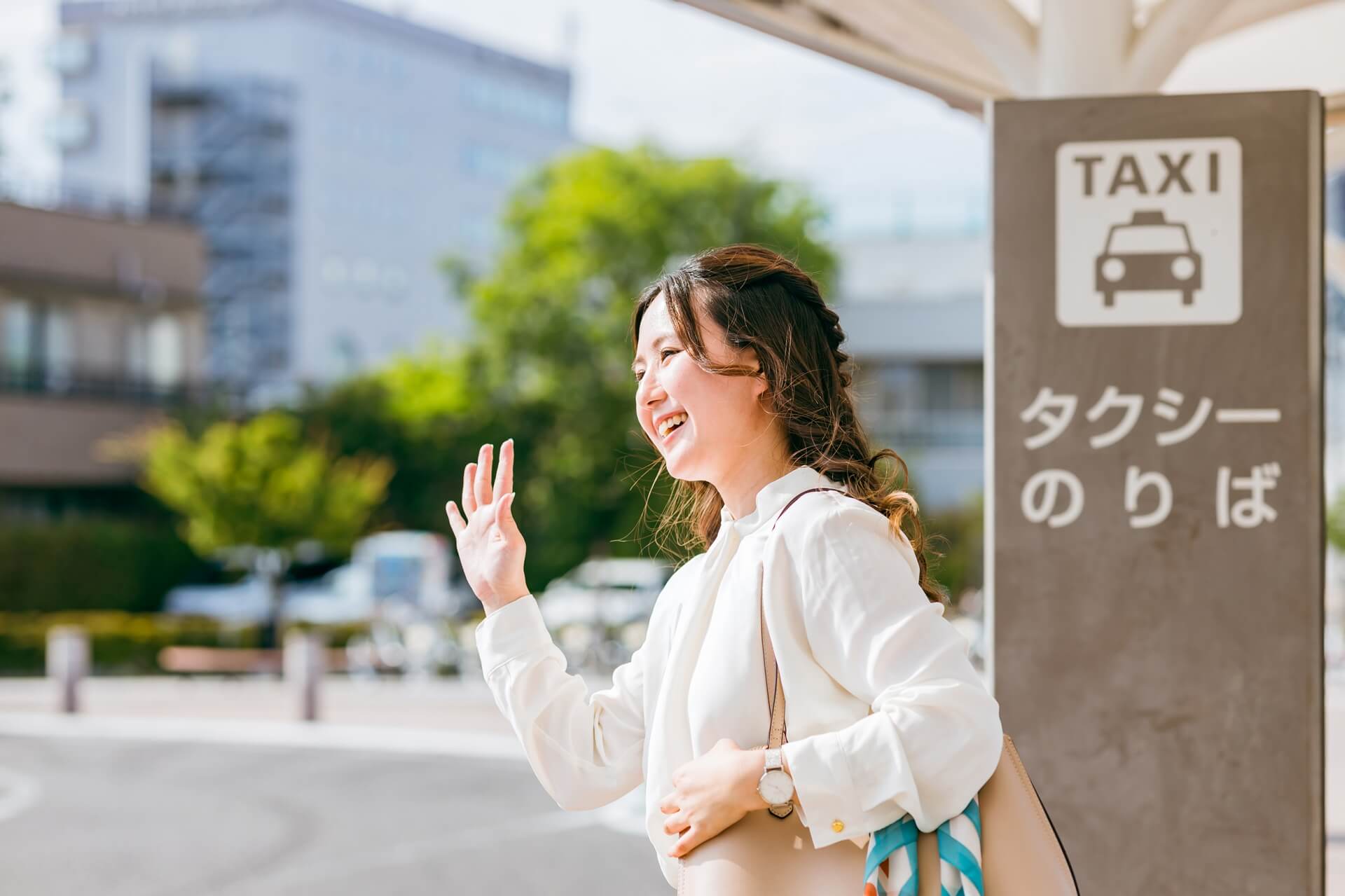 タクシー乗り場で手を振る女性